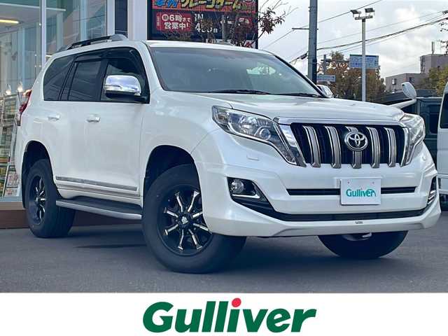 トヨタ ランドクルーザー プラド TX Lパッケージ・G－フロンティア 道央・札幌 2016(平28)年 7.7万km ホワイトパールクリスタルシャイン ・4WD/・社外ナビ　品番CN-RA04WD/(フルセグ/AM/FM/CD/DVD/BT)/・社外エンジンスターター/・社外ドライブレコーダー/・社外ETC/・バックカメラ/・レザーシート（ブラウン）/・D席/N席パワーシート/・D席/N席シートヒーター/・社外　18インチAW/・純正フロアマット/・ルーフレール/・ドアバイザー/・クルーズコントロール/・ダウンヒルアシスト/・LEDヘッドライト/・オートライト/・ヘッドライトウォッシャー/・フォグランプ/・盗難防止装置/・横滑り防止装置/・スマートキー/・プッシュスタート/・モデリスタエアロ/・保証書/・取扱説明書