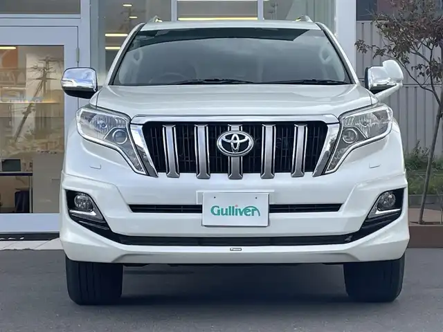 トヨタ ランドクルーザー プラド TX Lパッケージ・G－フロンティア 道央・札幌 2016(平28)年 7.7万km ホワイトパールクリスタルシャイン ・4WD/・社外ナビ　品番CN-RA04WD/(フルセグ/AM/FM/CD/DVD/BT)/・社外エンジンスターター/・社外ドライブレコーダー/・社外ETC/・バックカメラ/・レザーシート（ブラウン）/・D席/N席パワーシート/・D席/N席シートヒーター/・社外　18インチAW/・純正フロアマット/・ルーフレール/・ドアバイザー/・クルーズコントロール/・ダウンヒルアシスト/・LEDヘッドライト/・オートライト/・ヘッドライトウォッシャー/・フォグランプ/・盗難防止装置/・横滑り防止装置/・スマートキー/・プッシュスタート/・モデリスタエアロ/・保証書/・取扱説明書