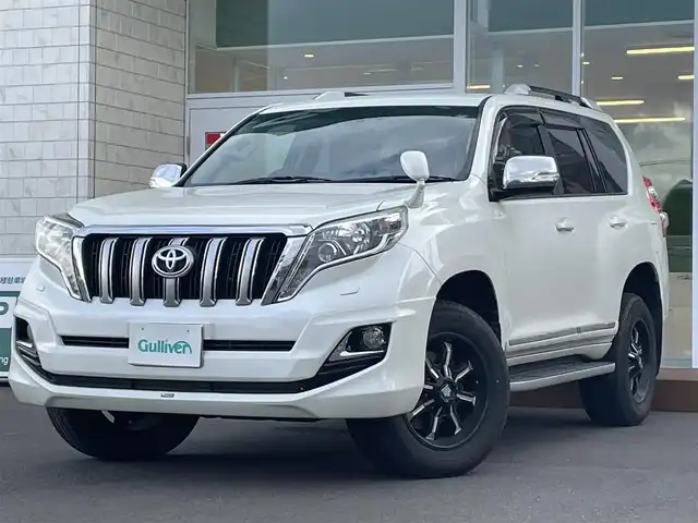 トヨタ ランドクルーザー プラド TX Lパッケージ・G－フロンティア 道央・札幌 2016(平28)年 7.7万km ホワイトパールクリスタルシャイン ・4WD/・社外ナビ　品番CN-RA04WD/(フルセグ/AM/FM/CD/DVD/BT)/・社外エンジンスターター/・社外ドライブレコーダー/・社外ETC/・バックカメラ/・レザーシート（ブラウン）/・D席/N席パワーシート/・D席/N席シートヒーター/・社外　18インチAW/・純正フロアマット/・ルーフレール/・ドアバイザー/・クルーズコントロール/・ダウンヒルアシスト/・LEDヘッドライト/・オートライト/・ヘッドライトウォッシャー/・フォグランプ/・盗難防止装置/・横滑り防止装置/・スマートキー/・プッシュスタート/・モデリスタエアロ/・保証書/・取扱説明書