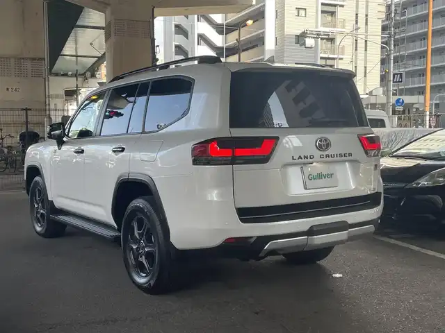 トヨタ ランドクルーザー GRスポーツ 大阪府 2023(令5)年 0.1万km プレシャスホワイトパール トヨタセーフティセンス/・プリクラッシュセーフティ/・レーントレーシングアシスト/・レーンディパーチャーアラート/・ドライバー異常時対応アシスト/・レーダークルーズコントロール/・ロードサインアシスト/・パーキングサポートブレーキ/（前後静止物・後方接近車両・後方歩行者）/・アダプティブハイビームシステム/T-Connectナビゲーションシステム/・JBLプレミアムサウンドシステム/・バックカメラ/・アラウンドビューモニター/・フルセグTV/クールBOX/トヨタ純正18インチホイール（マットグレー塗装）/・Bluetooth/先行発進告知機能/ブラインドスポットモニター/サイドステップ/パワーバックドア/ステアリングヒーター/ルーフレール/ワンオーナー/新車保証書/取扱説明書