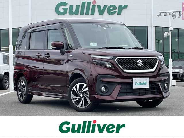 スズキ ソリオ バンディット HV MV 佐賀県 2022(令4)年 1.3万km メロウディープレッドパール ワンオーナー/純正８インチメモリナビ/・フルセグTV/CD/DVD/USB/Bluetooth/全方位モニター/ビルトインETC/ヘッドアップディスプレイ/両側パワースライドドア/後席用サイドサンシェード/D＋N席シートヒーター/革巻きステアリング/ステアリングリモコン/純正15インチアルミホイール/純正LEDヘッドライト/純正LEDフォグライト/純正フロアマット/純正ドアバイザ―/新車保証書/取扱説明書/スペアキー１本/セーフティーサポート/・デュアルカメラブレーキサポート/・誤発進抑制機能/・後退時ブレーキサポート/・後方誤発進抑制機能/・リアパーキングセンサー/・車線逸脱抑制機能/・車線逸脱警報機能/・ふらつき警報機能/・先行車発進お知らせ機能/・アダプティブクルーズコントロール/・ハイビームアシスト/・標識認識機能