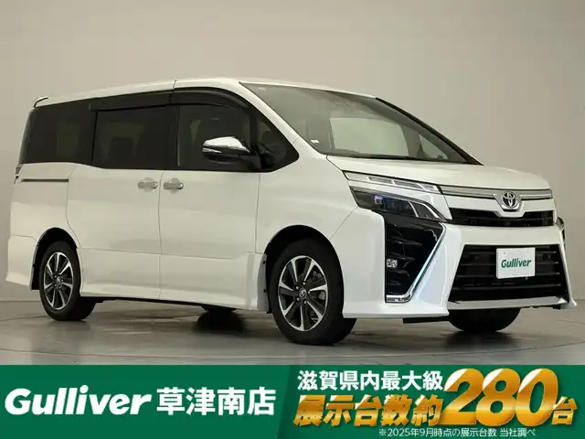 トヨタ ヴォクシー ZS 煌Ⅲ 滋賀県 2021(令3)年 1.7万km ホワイトパールクリスタルシャイン 純正10インチナビ（Bluetooth/CD/DVD/フルセグ）/Bカメ/両側電動パワースライド/ハーフレザーシート/純正フリップダウンモニター（リモコンなし）/クルーズコントロール/クリアランスソナー/LDA/PCS/LED/AHB/前後ドラレコ/ビルトインETC2.0/純正マット/ドアバイザー/プッシュスタート/ステアリングリモコン/リアロールサンシェード/MT付AT