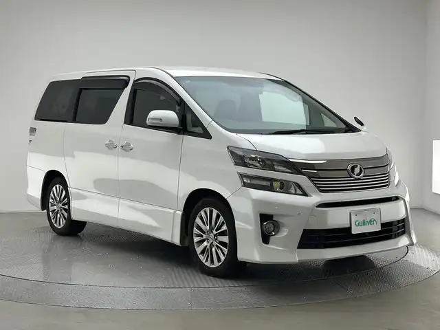 トヨタ ヴェルファイア 2．4Z ゴールデンアイズⅡ 兵庫県 2014(平26)年 7万km ホワイトパールクリスタルシャイン 純正SDナビ(CD/DVD/SD/Bluetooth/フルセグ)/純正フリップダウンモニター/バックカメラ/コーナーセンサー/両側パワースライドドア/パワーバックドア/クルーズコントロール/ハーフレザーシート/オットマン/純正18インチアルミホイール/純正フロアマット/ビルトインETC/HIDヘッドライト/ドライブレコーダー/オートライト