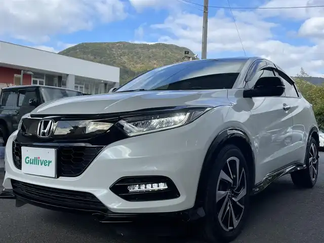 ホンダ ヴェゼル RS ホンダセンシング 長崎県 2020(令2)年 1.8万km プラチナホワイトパール ワンオーナー車両/Gathers8インチナビ（フルセグ、CD、DVD、AM、FM、BTA、USB、iPod）/バックカメラ/プッシュスタート/ビルトインETC/アイドリングストップ/電動パーキング/ブレーキホールド/アダプティブクルーズコントロール/パドルシフト/ステアリングリモコン/CMBS警報/ACC先行車検知/先行車発進お知らせ機能/路外逸脱抑制システム/レーンキープアシストシステム/標識認識機能/電格ウィンカーミラー/衝突軽減システム/横滑り防止機能/DNシートヒータ/ハーフレザー/Wエアバッグ/カーテンエアバッグ/ドアバイザー/前後ドラレコCELLSTAR/純正フロアマット/スペアキー/取説/保証書/ナビ取説