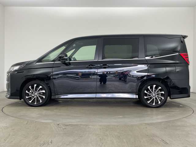 トヨタ ノア ハイブリッド S－Z 兵庫県 2024(令6)年 0.7万km アティチュードブラックマイカ ・純正ナビ機能付きディスプレイオーディオ/・AM・FM・CD・DVD・USB・MiraCast/・フルセグTV/・BT/・バックカメラ/・前席シートヒーター/・前後ドライブレコーダー/・Apple Car Play・AndroidAuto/・ビルトインETC2.0/・両側パワースライドドア/・純正フリップダウンモニター/・デジタルインナーミラー/・左右独立エアコン/・後席エアコン/・電子パーキングブレーキ/・オートホールド/・AC100V/・トヨタセーフティセンス/レーンディパーチャーアラート/プリクラッシュセーフティ/プロアクティブドライビングアシスト/パーキングサポートブレーキ/ヘッドアップディスプレイ/ロードサインアシスト/レーダークルーズコントロール/オートマチックハイビーム/発進遅れ告知/後退速度抑制/・ヘッドライトレベライザー/・革巻ステアリング/・ステアリングスイッチ/・ドライブモード（パワー・エコ）/・オールオートパワーウィンドウ/・ウインカーミラー/・フォグランプ/・横滑り防止装置/・純正フロアマット/・純正アルミホイール/・取扱説明書/・保証書/・スペアキー