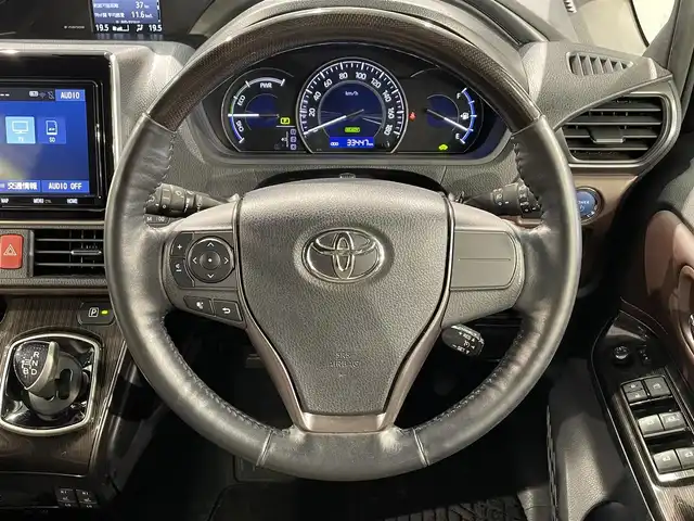 トヨタ エスクァイア ハイブリッド Gi プレミアムパッケージ 愛知県 2018(平30)年 3.4万km ブラック 純正9インチナビ（Bluetooth/フルセグTV/SD/AM/FM/CD/DVD）/純正12.1インチフリップダウンモニター/純正モデリスタフロントエアロ/トヨタセーフティセンス/被害軽減システム/両側パワースライドドア/ビルトインETC/LEDヘッドライト/シートヒーター/ステアリングヒーター/レーンキープアシスト/クルーズコントロール/バックカメラ/USB接続/プッシュスタート/スマートキー/スペアキー/純正フロアマット/純正15インチアルミホイール/ハーフレザーシート/ドアバイザー