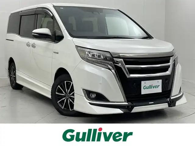 トヨタ エスクァイア ハイブリッド Gi プレミアムパッケージ ブラックテーラード 茨城県 2019(令1)年 5.4万km ホワイトパールクリスタルシャイン 純正9型ナビ/バックカメラ/フルセグ/TRDエアロ/TRDフロントグリル/AC100V/衝突被害軽減ブレーキ/車線逸脱抑制装置/クルーズコントロール/オートマチックハイビーム/クリアランスソナー/両側電動スライドドア/ETC2.0/シートヒーター/社外15インチAW/LEDヘッドライト/スマートキー