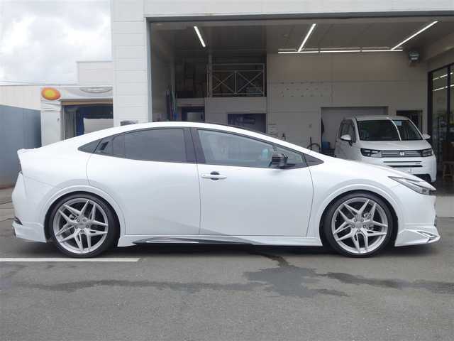 トヨタ プリウス Z 静岡県 2023(令5)年 0.7万km プラチナホワイトパールマイカ ワンオーナー・禁煙車/＜外装＞/モデリスタNEO ADVANCE STYLEエアロ/　フロントスポイラー/　サイドスカート/サイドガーニッシュ/　リヤスタイリングキット/　GRテールゲートスポイラー同色塗装/　フロント・リヤアーチ周り同色塗装/TEIN FREX車高調整キット/　アライメント調整済み/WORK グノーシス20インチAW/　タイヤ前後アゼニス225/35ZR20/パノラマルーフ・パワーバックドア/＜内装＞マチュアレッド色/12.3型ディスプレイオーディオプラス/コネクティッドナビ　フルセグ（TVキット）/パノラミックビューモニター/ビルトインETC2.0/純正デジタルインナーミラー/トヨタセーフティーセンス/　トヨタチームメイト/　メーカーオプション/　ドライブレコーダー前後方/　ブラインドスポットモニター/　安心降車アシスト+後方車両接近/　周辺車両接近時サポート/　後方車両への接近警報/　セカンダリーコリジョンブレーキ/ワイヤレス充電器/純正レクサスNX用シフトノブ/前席シートヒーター・ベンチレーション/アクセサリーコンセント/　AC100V 1500W/各種社外ピアノブラックパネル/純正フロアマット/　