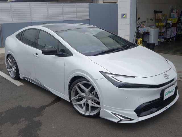 トヨタ プリウス Z 静岡県 2023(令5)年 0.7万km プラチナホワイトパールマイカ ワンオーナー・禁煙車/＜外装＞/モデリスタNEO ADVANCE STYLEエアロ/　フロントスポイラー/　サイドスカート/サイドガーニッシュ/　リヤスタイリングキット/　GRテールゲートスポイラー同色塗装/　フロント・リヤアーチ周り同色塗装/TEIN FREX車高調整キット/　アライメント調整済み/WORK グノーシス20インチAW/　タイヤ前後アゼニス225/35ZR20/パノラマルーフ・パワーバックドア/＜内装＞マチュアレッド色/12.3型ディスプレイオーディオプラス/コネクティッドナビ　フルセグ（TVキット）/パノラミックビューモニター/ビルトインETC2.0/純正デジタルインナーミラー/トヨタセーフティーセンス/　トヨタチームメイト/　メーカーオプション/　ドライブレコーダー前後方/　ブラインドスポットモニター/　安心降車アシスト+後方車両接近/　周辺車両接近時サポート/　後方車両への接近警報/　セカンダリーコリジョンブレーキ/ワイヤレス充電器/純正レクサスNX用シフトノブ/前席シートヒーター・ベンチレーション/アクセサリーコンセント/　AC100V 1500W/各種社外ピアノブラックパネル/純正フロアマット/　
