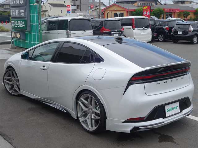 トヨタ プリウス Z 静岡県 2023(令5)年 0.7万km プラチナホワイトパールマイカ ワンオーナー・禁煙車/＜外装＞/モデリスタNEO ADVANCE STYLEエアロ/　フロントスポイラー/　サイドスカート/サイドガーニッシュ/　リヤスタイリングキット/　GRテールゲートスポイラー同色塗装/　フロント・リヤアーチ周り同色塗装/TEIN FREX車高調整キット/　アライメント調整済み/WORK グノーシス20インチAW/　タイヤ前後アゼニス225/35ZR20/パノラマルーフ・パワーバックドア/＜内装＞マチュアレッド色/12.3型ディスプレイオーディオプラス/コネクティッドナビ　フルセグ（TVキット）/パノラミックビューモニター/ビルトインETC2.0/純正デジタルインナーミラー/トヨタセーフティーセンス/　トヨタチームメイト/　メーカーオプション/　ドライブレコーダー前後方/　ブラインドスポットモニター/　安心降車アシスト+後方車両接近/　周辺車両接近時サポート/　後方車両への接近警報/　セカンダリーコリジョンブレーキ/ワイヤレス充電器/純正レクサスNX用シフトノブ/前席シートヒーター・ベンチレーション/アクセサリーコンセント/　AC100V 1500W/各種社外ピアノブラックパネル/純正フロアマット/　