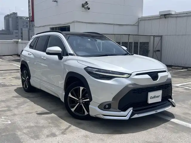 トヨタ カローラ クロス ハイブリッド Z 広島県 2023(令5)年 2.3万km プラチナホワイトパールマイカ ○走行距離：22468km（入庫時）/ワンオーナー/純正9インチディスプレイ・ナビ/フルセグTV・パノラミックビュー/ブラインドスポットモニター/ガラスルーフ/モデリスタエアロ/パワーバックドア/フロントシートヒーター/パワーシート/セーフティセンス/LEDヘッドライト/LEDフォグライト/保証書あり/取り扱い説明書あり/スペア（スマートキー）あり