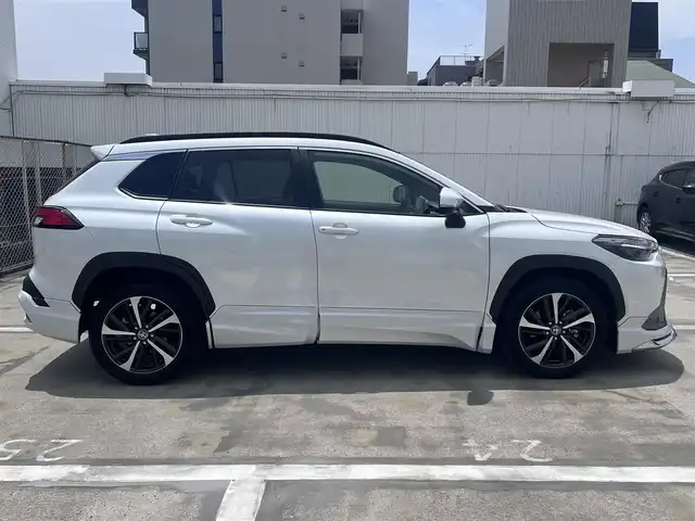 トヨタ カローラ クロス ハイブリッド Z 広島県 2023(令5)年 2.3万km プラチナホワイトパールマイカ ○走行距離：22468km（入庫時）/ワンオーナー/純正9インチディスプレイ・ナビ/フルセグTV・パノラミックビュー/ブラインドスポットモニター/ガラスルーフ/モデリスタエアロ/パワーバックドア/フロントシートヒーター/パワーシート/セーフティセンス/LEDヘッドライト/LEDフォグライト/保証書あり/取り扱い説明書あり/スペア（スマートキー）あり