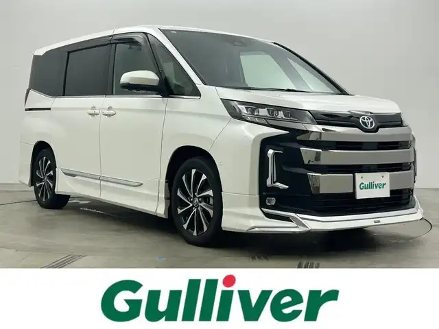 トヨタ ノア ハイブリッド S－Z 岡山県 2023(令5)年 1.2万km ホワイトパールクリスタルシャイン 純正10.5インチナビ/・地デジ/Bluetooth/DVD/CD/HDMI/パノラミックビューモニター/快適利便パッケージ/モデリスタエアロ /ブラインドスポットモニター/ビルトインETC2.0/両側パワースライドドア/ハーフレザーシート /シートヒーター /ステアリングヒーター/三眼LEDライト/ユニバーサルステップ/アドバンストパーク/パワーバックドア /オットマン/オートライト/オートハイビーム /レーダークルーズコントロール/プッシュスタート /スマートキー/純正17インチアルミホイール/新車保証書/取扱説明書