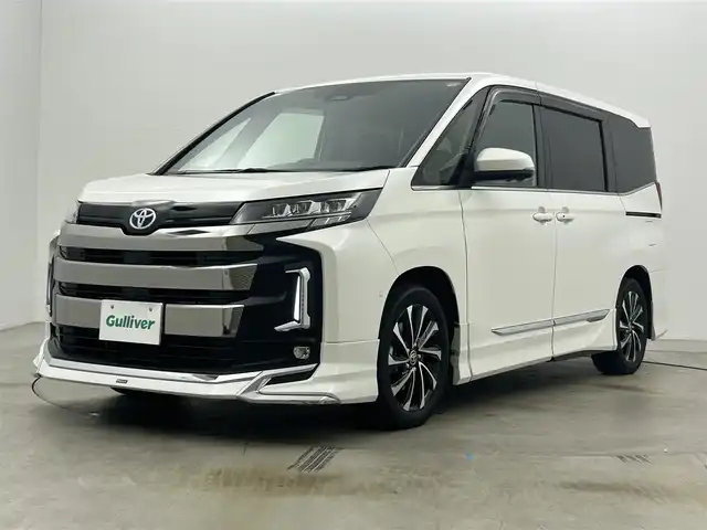 トヨタ ノア ハイブリッド S－Z 岡山県 2023(令5)年 1.2万km ホワイトパールクリスタルシャイン 純正10.5インチナビ/・地デジ/Bluetooth/DVD/CD/HDMI/パノラミックビューモニター/快適利便パッケージ/モデリスタエアロ /ブラインドスポットモニター/ビルトインETC2.0/両側パワースライドドア/ハーフレザーシート /シートヒーター /ステアリングヒーター/三眼LEDライト/ユニバーサルステップ/アドバンストパーク/パワーバックドア /オットマン/オートライト/オートハイビーム /レーダークルーズコントロール/プッシュスタート /スマートキー/純正17インチアルミホイール/新車保証書/取扱説明書