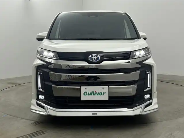 トヨタ ノア ハイブリッド S－Z 岡山県 2023(令5)年 1.2万km ホワイトパールクリスタルシャイン 純正10.5インチナビ/・地デジ/Bluetooth/DVD/CD/HDMI/パノラミックビューモニター/快適利便パッケージ/モデリスタエアロ /ブラインドスポットモニター/ビルトインETC2.0/両側パワースライドドア/ハーフレザーシート /シートヒーター /ステアリングヒーター/三眼LEDライト/ユニバーサルステップ/アドバンストパーク/パワーバックドア /オットマン/オートライト/オートハイビーム /レーダークルーズコントロール/プッシュスタート /スマートキー/純正17インチアルミホイール/新車保証書/取扱説明書