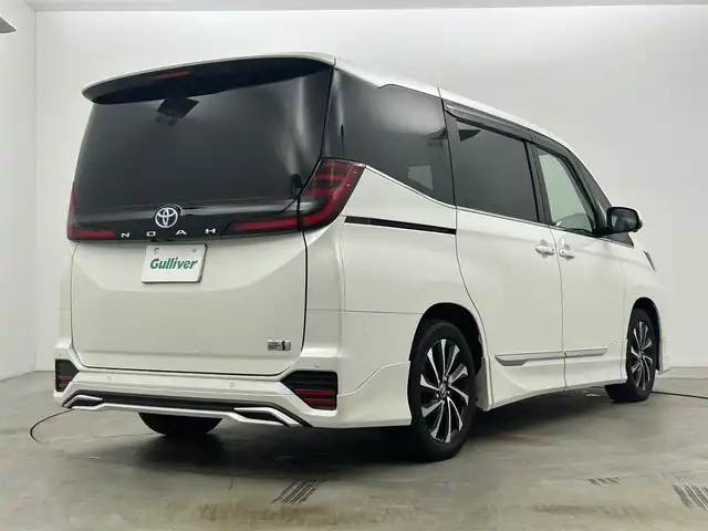 トヨタ ノア ハイブリッド S－Z 岡山県 2023(令5)年 1.2万km ホワイトパールクリスタルシャイン 純正10.5インチナビ/・地デジ/Bluetooth/DVD/CD/HDMI/パノラミックビューモニター/快適利便パッケージ/モデリスタエアロ /ブラインドスポットモニター/ビルトインETC2.0/両側パワースライドドア/ハーフレザーシート /シートヒーター /ステアリングヒーター/三眼LEDライト/ユニバーサルステップ/アドバンストパーク/パワーバックドア /オットマン/オートライト/オートハイビーム /レーダークルーズコントロール/プッシュスタート /スマートキー/純正17インチアルミホイール/新車保証書/取扱説明書