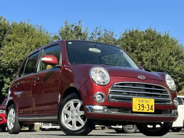 ダイハツ ミラ ジーノ プレミアムX 東京都 2008(平20)年 8.8万km ルージュレッドクリスタルメタリック フロントフォグランプ/MOMO製本木製ステアリングホイール/木目調シフトノブ/タン革/スエード調ファブリックコンビシート/carrozzeriaオーディオ（MVH-5600）/・Bluetoothオーディオ/AUX/FM/AM/ETC/取扱説明書/保証書