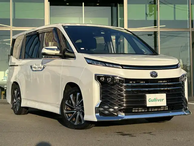トヨタ ヴォクシー S－Z 愛媛県 2023(令5)年 1.2万km ホワイトパールクリスタルシャイン 純正10.5型ディスプレイオーディオプラス/CD/DVD/フルセグTV/Bluetooth/HDMI/純正13.2インチフリップダウンモニター/ガイド付きバックカメラ/プリクラッシュセーフティシステム/レーントレーシングアシスト/パーキングサポートブレーキ/レーダークルーズコントロール/プロジェクター式LEDヘッドライト/ハーフレザーシート/前席シートヒーター/両側パワースライドドア/オートライト/革巻きステアリング/ステアリングスイッチ/純正17インチAW/プッシュスタート/TVキャンセラー/ビルトインETC2.0/前方ドライブレコーダー/フロアマット/オート電動格納ミラー