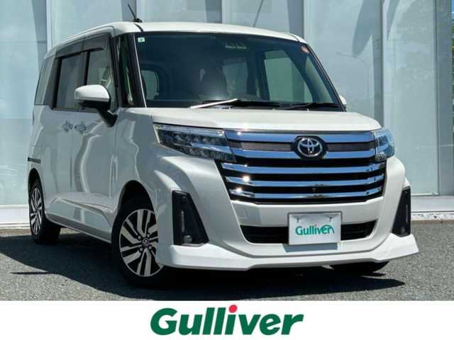 トヨタ ルーミー カスタムG 福岡県 2021(令3)年 2.5万km パールホワイトⅢ ・純正9インチディスプレイオーディオ/（ラジオ/フルセグ/Bluetooth/USB/iPod/交通情報）/・両側パワースライドドア/・アラウンドビューモニター/・ビルドインETC/・衝突被害軽減システム/・クリアランスソナー/・横滑り防止装置/・LEDヘッドライト/・追従型クルーズコントロール/・電動パーキングブレーキ/・ステアリングスイッチ/・オート電動格納ミラー/・D/N席シートヒーター/・ドアバイザー/・リアテーブル/・ISOFIX