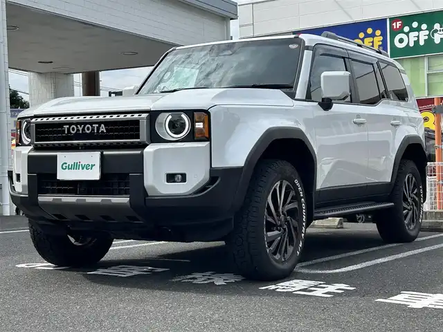トヨタ ランドクルーザー ２５０ VX 長崎県 2024(令6)年 0.3万km プラチナホワイトパールマイカ ワンオーナー/純正ディスプレイオーディオ/(FM/AM/BT/フルセグTV/Miracast/ナビ)/プッシュスタート/MTモード付AT/フルタイム4WD/ビルトインETC/全方位カメラ/サンルーフ/ルーフレール/レーダークルーズコントロール/ドライブレコーダー内蔵型デジタルインナーミラー/純正フロアマット/モデリスタR20アルミホイール/ステアリングヒーター/レザーシート/D席パワーシート/DN席シートヒーター/DN席エアシート/3列シート/パワーバックドア/オートライト/オートハイビーム/ABS/TRC/VSC/LDA/BSM/PCS/PDA/RCTA/RCD/RSA/クリアランスソナー/SRSダブルエアバッグ/SRSサイドエアバッグ/スマートキー/スペアキー/取扱説明書/保証書