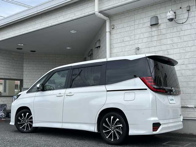 トヨタ ノア ハイブリッド S－Z 神奈川県 2024(令6)年 0.5万km ホワイトパールクリスタルシャイン ワンオーナー/純正ナビ（AM・FM・CD・DVD・HDMI・BT・TV・miracast）/バックカメラ/全方位モニター/ハーフレザーシート/ETC2.0/前後ドライブレコーダー/フリップダウンモニター/快適利便パッケージ/・パワーバックドア/・ナノイーX/・両側パワースライドドア/・2列目オットマン、シートヒーター/・ステアリングヒーター/レーダークルーズコントロール（全車速追従機能付き）/レーンチェンジアシスト/パーキングアシスト/ドライビングアシスト/純正フロアマット/純正ドアバイザー/オートライト/オートマチックハイビーム/AC100V充電/クリアランスソナー/フォグランプ/保証書/スペアキー×1