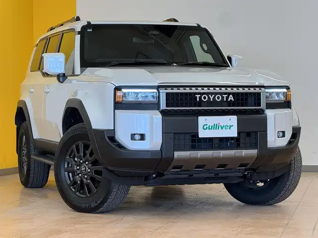 トヨタ ランドクルーザー ２５０ VX 群馬県 2024(令6)年 1万km プラチナホワイトパールマイカ トヨタセーフティセンス/・プリクラッシュセーフティ/・レーンディパーチャーアラート/・ブラインドスポットモニター/・リヤクロストラフィックアラート/・リヤカメラディテクション/・プロアクティブドライビングアシスト/・クリアランスソナー/・ロードサインアシスト/・レーダークルーズコントロール/・オートマチックハイビーム/純正12.3インチディスプレイオーディオ（ナビ機能付き）/　　フルセグTV/　　FM/AM/BT/USB/AppleCarPlay/AndroidAuto/パノラミックビューモニター/サンルーフ/パワーバックドア/LEDオートライト/黒レザーシート/パワーシート/シートヒーター/エアシート/デュアルオートエアコン/純正18インチAW/ルーフレール/デジタルインナーミラー/革巻きステアリング/ステアリングスイッチ/ステアリングヒーター/フォグランプ/ヘッドライトウォッシャー/電動パーキングブレーキ/オートホールド/MTモード付AT/トランスファーレバー/オートワイパー/横滑り防止機能/前後ドライブレコーダー/スマートキー/ビルトインETC2.0