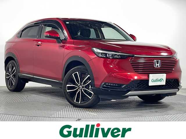 ホンダ ヴェゼル ハイブリッド e:HEV Z 広島県 2021(令3)年 2.7万km プレミアムクリスタルレッドM 9型HondaConnectディスプレイ（ナビ/フルセグTV/AppleCarPlay/AndroidAuto）/パワーテールゲート/シートヒーター/ハーフレザーシート/ステアリングヒーター/ホンダセンシング/・衝突軽減ブレーキ/・レーンキープアシスト/・アダプティブクルーズコントロール/・オートハイビーム/・誤発進抑制機能/・パーキングセンサー/・ブラインドスポットモニター/・後退出庫サポート/ヒルディセントコントロール/減速セレクター/ステアリングスイッチ/電動パーキングブレーキ/オートブレーキホールド/ETC2.0/ワイヤレス充電/USB入力端子/ドライブレコーダー