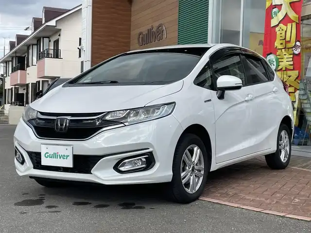 ホンダ フィット ハイブリット L ホンダセンシング 道央・札幌 2018(平30)年 4.6万km プラチナホワイトパール 登録時走行距離46031km/ワンオーナー/　４　W　D　/ホンダセンシング/寒冷地仕様/社外メモリナビ（CD/DVD/FM/AM/SD/BT)/フルセグ（走行中視聴可能）/バックカメラ/ウィンカーミラー/クルーズコントロール（追従走行あり）/ドアバイザー/プッシュスタート/ビルトインETC/スペアキー×１/純正エンジンスターター/USB入力端子/ドライブレコーダー（前方）/ハーフレザーシート/純正フロアマット/横滑り防止装置/盗難防止装置/衝突軽減ブレーキ/レーンキープアシスト/オートライト/フォグランプ/フロントデアイサースイッチ/ECONスイッチ/電動格納ミラー/バニティミラー/ワイパー間欠時間コントローラー/Sモードスイッチ/積込冬タイヤ（純正WCP/185/60/R15/18年製/溝4mm）