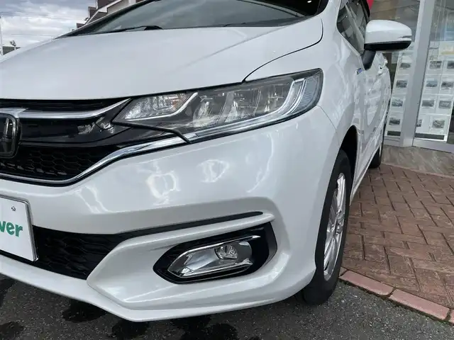 ホンダ フィット ハイブリット L ホンダセンシング 道央・札幌 2018(平30)年 4.6万km プラチナホワイトパール 登録時走行距離46031km/ワンオーナー/　４　W　D　/ホンダセンシング/寒冷地仕様/社外メモリナビ（CD/DVD/FM/AM/SD/BT)/フルセグ（走行中視聴可能）/バックカメラ/ウィンカーミラー/クルーズコントロール（追従走行あり）/ドアバイザー/プッシュスタート/ビルトインETC/スペアキー×１/純正エンジンスターター/USB入力端子/ドライブレコーダー（前方）/ハーフレザーシート/純正フロアマット/横滑り防止装置/盗難防止装置/衝突軽減ブレーキ/レーンキープアシスト/オートライト/フォグランプ/フロントデアイサースイッチ/ECONスイッチ/電動格納ミラー/バニティミラー/ワイパー間欠時間コントローラー/Sモードスイッチ/積込冬タイヤ（純正WCP/185/60/R15/18年製/溝4mm）