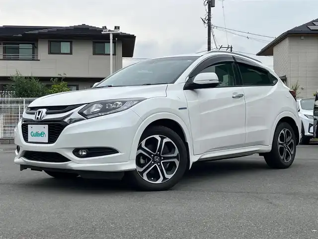 ホンダ ヴェゼル ハイブリッド Z 静岡県 2014(平26)年 4.9万km ホワイトオーキッドパール エンジンスタートボタン/スマートキー/スペアキー1本/パワーステアリング/パワーウィンドウ/MTモード付きAT/寒冷地仕様/オートエアコン/保証書/取扱説明書/記録簿/アイドリングストップ/クルーズコントロール/バックカメラ/純正ETC/純正ナビ（CD.DVD.BT.フルセグ）/純正フロアマット/純正アルミホイール/D席N席シートヒーター/ルーフレール/ABS/横滑り防止装置/オートライト/LEDライト/W+サイドエアバック/カーテンエアバック/衝突軽減システム