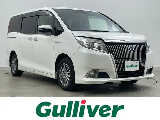 トヨタ エスクァイア ハイブリッド Gi 岡山県 2015(平27)年 7万km ホワイトパールクリスタルシャイン 社外9インチナビ(X900)/(Bluetooth/CD/DVD/フルセグTV)/社外10.1インチ後席モニター(TMX-RM300S)/両側電動スライドドア/合皮シート/シートヒーター(運転席・助手席)/バックカメラ/置くだけ充電/ドアバイザー/クルーズコントロール/純正LEDヘッドライト/オートライト/スマートキー(1本)/純正フロアマット/純正アルミホイール/ビルトインETC/アイドリングストップ