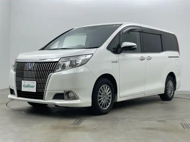 トヨタ エスクァイア ハイブリッド Gi 岡山県 2015(平27)年 7万km ホワイトパールクリスタルシャイン 社外9インチナビ(X900)/(Bluetooth/CD/DVD/フルセグTV)/社外10.1インチ後席モニター(TMX-RM300S)/両側電動スライドドア/合皮シート/シートヒーター(運転席・助手席)/バックカメラ/置くだけ充電/ドアバイザー/クルーズコントロール/純正LEDヘッドライト/オートライト/スマートキー(1本)/純正フロアマット/純正アルミホイール/ビルトインETC/アイドリングストップ