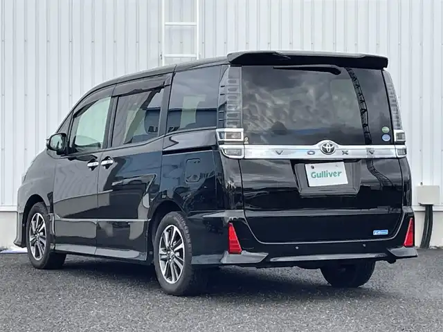 トヨタ ヴォクシー ZS 煌Ⅱ 熊本県 2019(令1)年 6.6万km イナズマスパーキングブラックガラスフレーク 社外ナビ/・BT/CD/DVD/SD/USB/AM/FM/・フルセグ/フリップダウンモニター/バックカメラ/前後ドラレコ/両側パワースライドドア/トヨタセーフティーセンス/ビルトインETC/革巻きステアリング/・ステアリングリモコン/クルーズコントロール/MTモード付AT/プッシュスタート/・スマートキー/・スペアキー×１/アイドリングストップ/純正AW/純正ドアバイザー/純正フロアマット/電動格納ミラー/・ミラーウィンカー/ロールサンシェード
