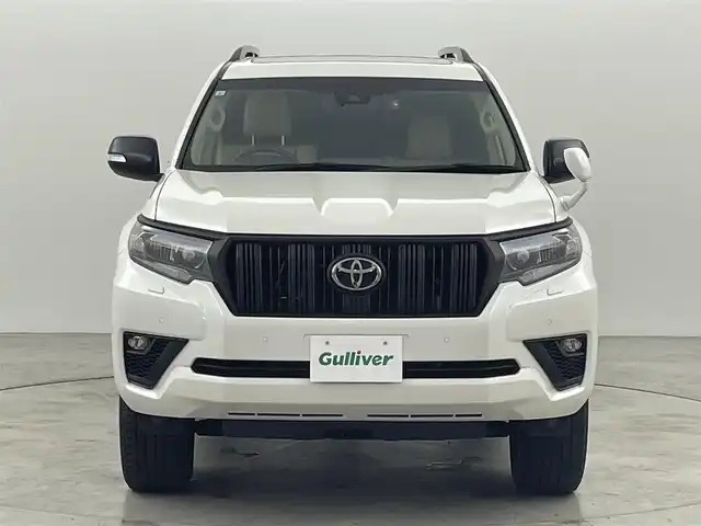 トヨタ ランドクルーザー プラド TX Lパッケージ マットブラED 福岡県 2023(令5)年 2.5万km ホワイトパールクリスタルシャイン ワンオーナー　/７人乗り　/サンルーフ　/ルーフレール　/社外８型ディスプレイオーディオ　/バックカメラ　/ビルトインＥＴＣ　/前方ドライブレコーダー　/レーダークルーズコントロール　/コーナーセンサー　/衝突被害軽減ブレーキ　/レーンキープ　/アクセル踏み間違い防止　/先行車発進お知らせ　/ＭＴモード付き　/寒冷地仕様　/ベージュ本革シート　/パワーシート　/ベンチレーション／シートヒーター　/ＬＥＤヘッドライト