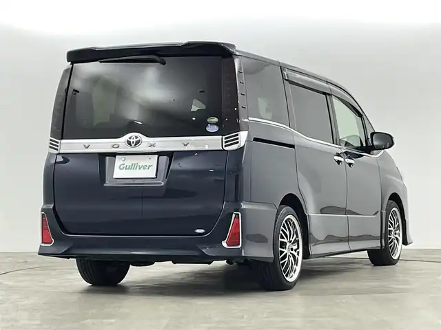 トヨタ ヴォクシー ZS 煌 福島県 2018(平30)年 9.3万km ブラッキッシュアゲハガラスフレーク トヨタセーフティセンス/・衝突被害軽減ブレーキ/・車線逸脱警報装置/・先行車発進お知らせ/・レーダークルーズコントロール/・オートマチックハイビーム/社外11インチナビ/・型番：EX11Z/・フルセグTV/BT/SD/USB/HDMI/CD/DVD/FM/AM/・前方ドライブレコーダー/・ETC/・バックカメラ/社外フリップダウン/両側パワースライドドア/アイドリングストップ/3列目シート/革張ステアリング/・ステアリングリモコン/レザーシート/プッシュスタート/・スマートキー/MTモード付AT/電動格納ミラー/・ウィンカーミラー/・オートミラー/LEDヘッドライト/・フォグランプ/・オートライト/純正マット/社外18インチアルミ/TRDエアロ（前）