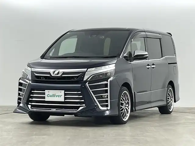 トヨタ ヴォクシー ZS 煌 福島県 2018(平30)年 9.3万km ブラッキッシュアゲハガラスフレーク トヨタセーフティセンス/・衝突被害軽減ブレーキ/・車線逸脱警報装置/・先行車発進お知らせ/・レーダークルーズコントロール/・オートマチックハイビーム/社外11インチナビ/・型番：EX11Z/・フルセグTV/BT/SD/USB/HDMI/CD/DVD/FM/AM/・前方ドライブレコーダー/・ETC/・バックカメラ/社外フリップダウン/両側パワースライドドア/アイドリングストップ/3列目シート/革張ステアリング/・ステアリングリモコン/レザーシート/プッシュスタート/・スマートキー/MTモード付AT/電動格納ミラー/・ウィンカーミラー/・オートミラー/LEDヘッドライト/・フォグランプ/・オートライト/純正マット/社外18インチアルミ/TRDエアロ（前）