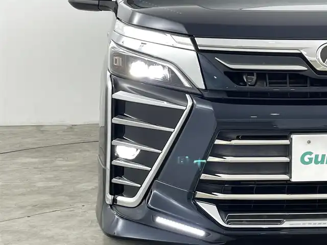トヨタ ヴォクシー ZS 煌 福島県 2018(平30)年 9.3万km ブラッキッシュアゲハガラスフレーク トヨタセーフティセンス/・衝突被害軽減ブレーキ/・車線逸脱警報装置/・先行車発進お知らせ/・レーダークルーズコントロール/・オートマチックハイビーム/社外11インチナビ/・型番：EX11Z/・フルセグTV/BT/SD/USB/HDMI/CD/DVD/FM/AM/・前方ドライブレコーダー/・ETC/・バックカメラ/社外フリップダウン/両側パワースライドドア/アイドリングストップ/3列目シート/革張ステアリング/・ステアリングリモコン/レザーシート/プッシュスタート/・スマートキー/MTモード付AT/電動格納ミラー/・ウィンカーミラー/・オートミラー/LEDヘッドライト/・フォグランプ/・オートライト/純正マット/社外18インチアルミ/TRDエアロ（前）
