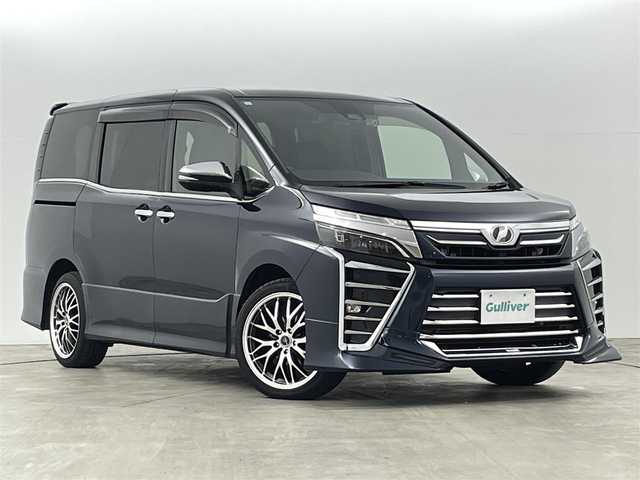トヨタ ヴォクシー ZS 煌 千葉県 2018(平30)年 9.3万km ブラッキッシュアゲハガラスフレーク トヨタセーフティセンス/・衝突被害軽減ブレーキ/・車線逸脱警報装置/・先行車発進お知らせ/・レーダークルーズコントロール/・オートマチックハイビーム/社外11インチナビ/・型番：EX11Z/・フルセグTV/BT/SD/USB/HDMI/CD/DVD/FM/AM/・前方ドライブレコーダー/・ETC/・バックカメラ/社外フリップダウン/両側パワースライドドア/アイドリングストップ/3列目シート/革張ステアリング/・ステアリングリモコン/レザーシート/プッシュスタート/・スマートキー/MTモード付AT/電動格納ミラー/・ウィンカーミラー/・オートミラー/LEDヘッドライト/・フォグランプ/・オートライト/純正マット/社外18インチアルミ/TRDエアロ（前）