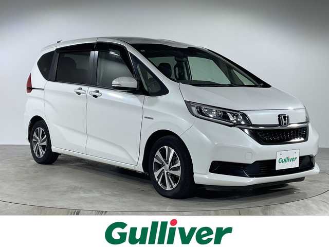 ホンダ フリード ハイブリット G ホンダセンシング 福岡県 2021(令3)年 4.2万km プラチナホワイトパール 純正9インチメモリナビ/・CD/DVD/BT/フルセグTV/・バックモニター/純正フリップダウンモニター/ホンダセンシング/両側パワースライドドア/ETC/ハーフレザーシート/・シートヒーター（D/N)/革巻きステアリング/・ステアリングリモコン/LED/・オートライト/スマートキー/・プッシュスタート/・スペアキー/純正15インチアルミホイール/純正フロアマット/純正ドアバイザー