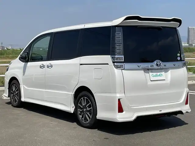 トヨタ ヴォクシー ZS 煌Ⅱ 佐賀県 2019(令1)年 4.9万km ホワイトパールクリスタルシャイン SiLK Blazeリアスポイラー・リアアンダー/社外フロントグリル/純正9インチナビ/・フルセグTV/CD/SD/Bluetooth/フリップダウンモニター/ドラレコ付きデジタルインナーミラー/バックカメラ/両側パワースライドドア/後席用サイドサンシェード/ISOFIX対応/ビルトインETC/革巻きステアリング/ステアリングリモコン/クルーズコントロール/レーンディパーチャーアラート/プリクラッシュブレーキ/先行車発進お知らせ機能/クリアランスソナー/ウィンカーミラー/純正LEDヘッドライト/純正LEDフォグライト/純正1６インチアルミ/スペアキー１本