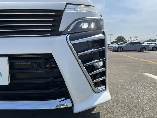 トヨタ ヴォクシー ZS 煌Ⅱ 佐賀県 2019(令1)年 4.9万km ホワイトパールクリスタルシャイン SiLK Blazeリアスポイラー・リアアンダー/社外フロントグリル/純正9インチナビ/・フルセグTV/CD/SD/Bluetooth/フリップダウンモニター/ドラレコ付きデジタルインナーミラー/バックカメラ/両側パワースライドドア/後席用サイドサンシェード/ISOFIX対応/ビルトインETC/革巻きステアリング/ステアリングリモコン/クルーズコントロール/レーンディパーチャーアラート/プリクラッシュブレーキ/先行車発進お知らせ機能/クリアランスソナー/ウィンカーミラー/純正LEDヘッドライト/純正LEDフォグライト/純正1６インチアルミ/スペアキー１本