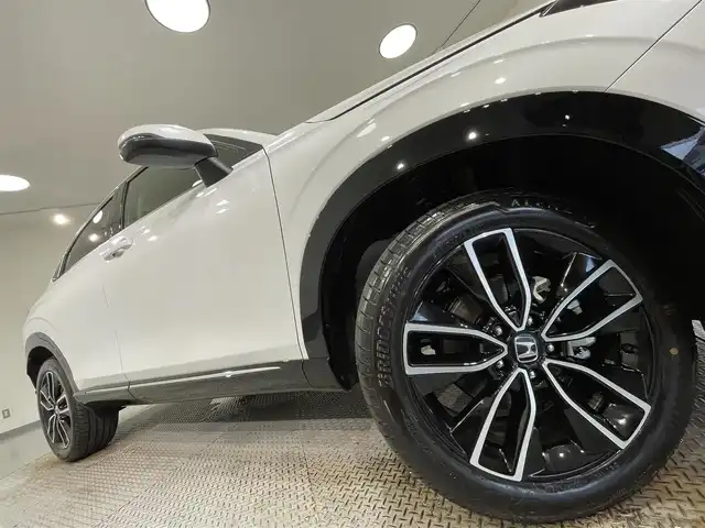 ホンダ ヴェゼル ハイブリッド e:HEV Z 愛知県 2025(令7)年 0.1千km プラチナホワイトパール 登録済未使用車/純正９インチホンダコネクトディスプレイナビ　/(Bluetooth/フルセグTV/USB/スマートフォン連携/FM/AM)/ホンダセンシング　/　　-衝突軽減ブレーキ（CMBS)/　　-誤発進抑制機能/　　-路線逸脱抑制機能/　　-アダプティブクルーズコントロール/　　-車線維持支援システム/　　-オートハイビーム/　　-先行車発進お知らせ/　　-標識認識機能/ビルトインＥＴＣ２．０　/ＬＥＤヘッドライト/LEDフォグランプ　/バックカメラ　/ワイヤレス充電　/シートヒーター/ステアリングヒーター　/電動バックドア　/ブラインドスポットモニター（ＢＳＭ）/コーナーセンサー/パドルシフト/プッシュスタート/　　-スマートキー