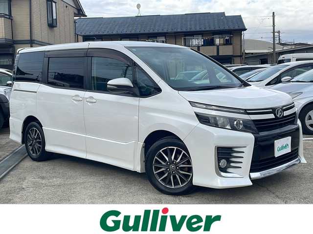 トヨタ ヴォクシー ZS 神奈川県 2014(平26)年 10万km ホワイトパールクリスタルシャイン 純正ナビ/（CD/DVD/AM/FM/SD/USB/AUX/BT/フルセグTV)/バックカメラ/前方ドライブレコーダー/ETC/左側パワースライドドア/右側スライドドア/プッシュスタート/横滑り防止装置/盗難防止装置/ブレーキアシスト/トラクションコントロール/ABS/アイドリングストップ/純正フロアマット/純正アルミホイール/スペアキー×１/保証書/取扱説明書