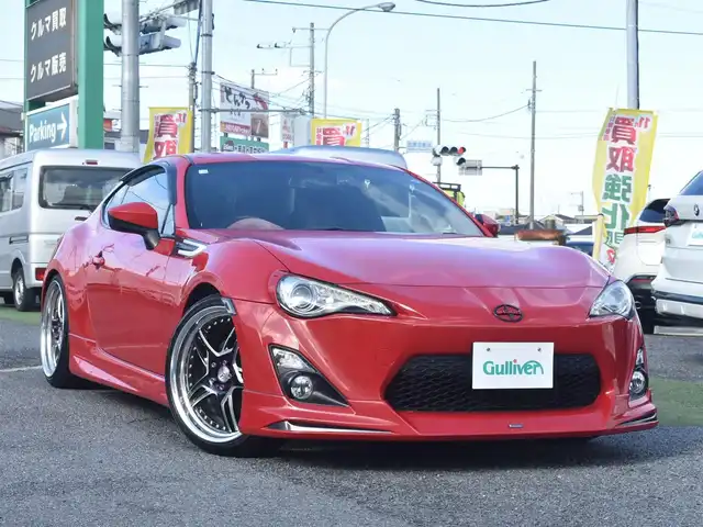 トヨタ ８６ GT リミテッド 神奈川県 2012(平24)年 5.7万km ライトニングレッド USトヨタ直輸入純正エンブレム/モデリスタエアロ（F・S・R）/TOM’S4本出しマフラー/：TOM’S4スモークテールレンズ/車高調/社外ディスプレイオーディオ/Bluetooth/バックカメラ/FM/AM/パイオニアパワードサブウーファー（）/プッシュスタート/ドライブレコーダー（前後）/社外シルバーメッキ19インチアルミホイール/：235/35R19/ハーフレザーシート/：シートヒーター前席/フロアマット