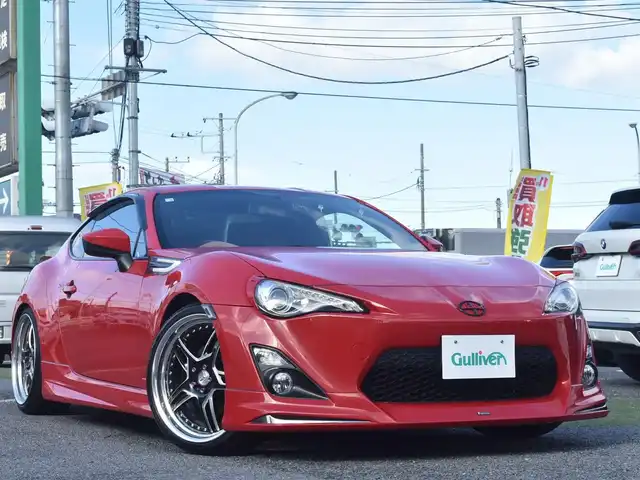 トヨタ ８６ GT リミテッド 神奈川県 2012(平24)年 5.7万km ライトニングレッド USトヨタ直輸入純正エンブレム/モデリスタエアロ（F・S・R）/TOM’S4本出しマフラー/：TOM’S4スモークテールレンズ/車高調/社外ディスプレイオーディオ/Bluetooth/バックカメラ/FM/AM/パイオニアパワードサブウーファー（）/プッシュスタート/ドライブレコーダー（前後）/社外シルバーメッキ19インチアルミホイール/：235/35R19/ハーフレザーシート/：シートヒーター前席/フロアマット