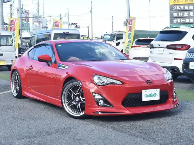 トヨタ ８６ GT リミテッド 神奈川県 2012(平24)年 5.7万km ライトニングレッド USトヨタ直輸入純正エンブレム/モデリスタエアロ（F・S・R）/TOM’S4本出しマフラー/：TOM’S4スモークテールレンズ/車高調/社外ディスプレイオーディオ/Bluetooth/バックカメラ/FM/AM/パイオニアパワードサブウーファー（）/プッシュスタート/ドライブレコーダー（前後）/社外シルバーメッキ19インチアルミホイール/：235/35R19/ハーフレザーシート/：シートヒーター前席/フロアマット