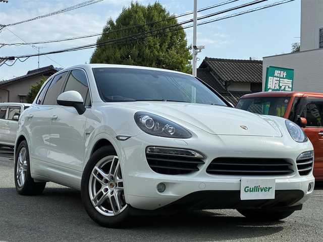 ポルシェ カイエン S ハイブリッド 熊本県 2013(平25)年 5万km ピュアホワイト サンルーフ/4WD/スーパーチャージャー/純正SDナビ/【フルセグTV/SD/CD/DVD/Bluetooth】/バックカメラ/クルーズコントロール/ダウンヒルアシストコントロール/本革シート/前席パワーシート/前席シートヒーター/電動リアゲート/純正19インチアルミホイール/社外サス（純正サス積込有）/パドルシフト/プライバシーガラス/オートLEDライト/横滑り防止装置/盗難防止装置/純正フロアマット/ダブル＋サイドエアバック/リモコンキー/スペアキー/取扱説明書/保証書
