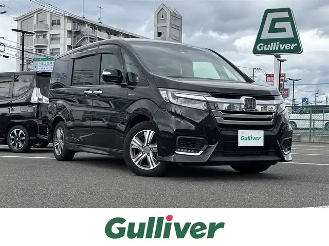 ホンダ ステップワゴン スパーダ ハイブリッド G EX ホンダセンシング 大分県 2018(平30)年 9万km プレミアムスパークルブラックパール 純正9型ナビ　VXM-187VFNi/フルセグTV、CD、DVD、Bluetooth/AM、FM/バックカメラ/ビルトインETC/前後ドライブレコーダー/両側パワースライドドア/左側ハンズフリースライドドア/リアオートエアコン/セカンドシートバックテーブル/ホンダセンシング/　・衝突軽減ブレーキ/　・誤発進抑制機能/　・歩行車事故低減ステアリング/　・路外逸脱抑制機能/　・渋滞追従機能付き/　・アダブティブクルーズコントロール/　・車線維持支援システム/　・先行車発進お知らせ機能/　・標識認識機能/電子制御パーキングシステム/オートブレーキホールド機能/前席シートヒーター/ハーフレザーシート/わくわくゲート