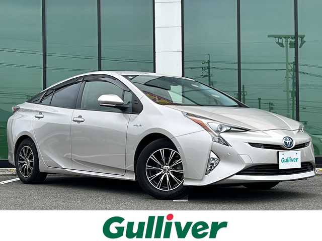 トヨタ プリウス Sセーフティプラス 福岡県 2016(平28)年 9.6万km スティールブロンドM ワンオーナー/純正9インチSDナビ【DSZT-YC4T】/【AM/FM/CD/DVD/Bluetooth/フルセグTV】/バックカメラ/ビルトインETC/前方ドライブレコーダー【DRT-H66A】/ヘッドアップディスプレイ/インテリジェントパーキングアシスト/Tyota Safety Sence P/・プリクラッシュセーフティ/・レーンディパーチャーアラート/・オートマチックハイビーム/・レーダークルーズコントロール/純正フロアマット/社外Rizley15インチAW/横滑り防止装置/盗難防止装置