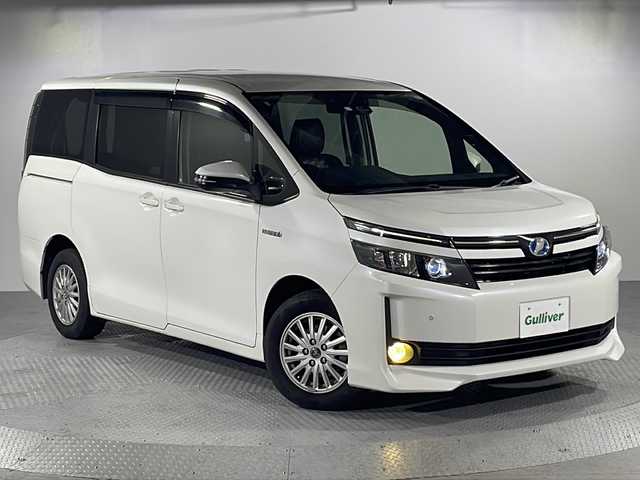 トヨタ ヴォクシー ハイブリッド V 沖縄県 2016(平28)年 9.1万km ホワイトパールクリスタルシャイン 【県外仕入れ】/・純正SDナビ/・フリップダウンモニター/・CD/DVD/BT/フルセグ/・バックカメラ/・ETC/・プリクラッシュセーフティ/・レーンキープアシスト/・クルーズコントロール/・コーナーセンサー/・横滑り防止装置/・オートマチックハイビーム/・アイドリングストップ/・左側パワースライドドア/・D+N席シートヒーター/・classioシートカバー/・LEDヘッドライト/・オートライト/・フォグランプ/・純正15インチAW/・純正フロアマット/・プッシュスタート/・スマートキー
